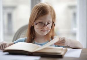 A Toddler Still Beats GPT-4 on Data Efficiency Young child pointing at words in a book, illustrating early language acquisition