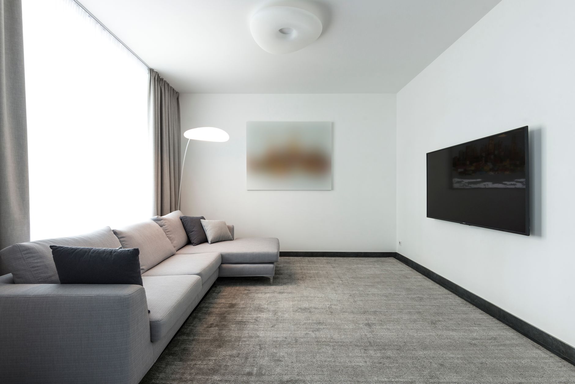Large flat-screen TV mounted on a white living room wall