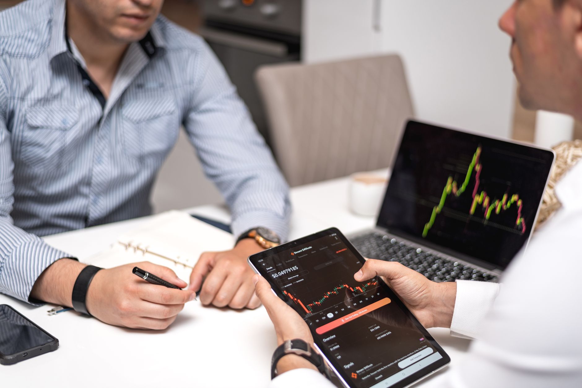 Business professionals reviewing fintech acquisition documents at a conference table