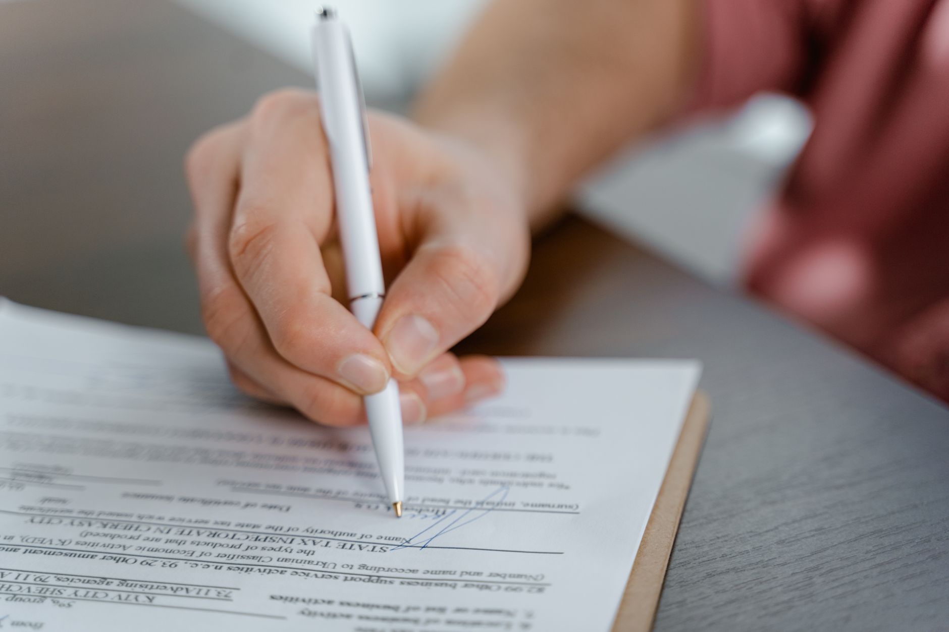 Legal patent documents spread on a desk with a pen