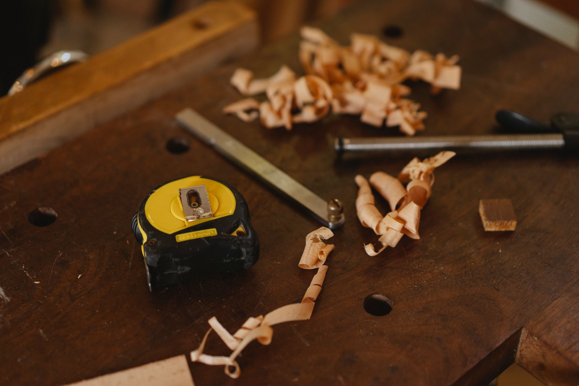 Tape measure and hand tools laid out on a wooden surface