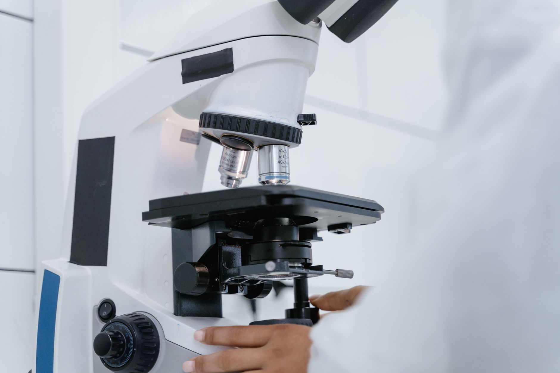 Scientist examining samples under a microscope in a pediatric research laboratory