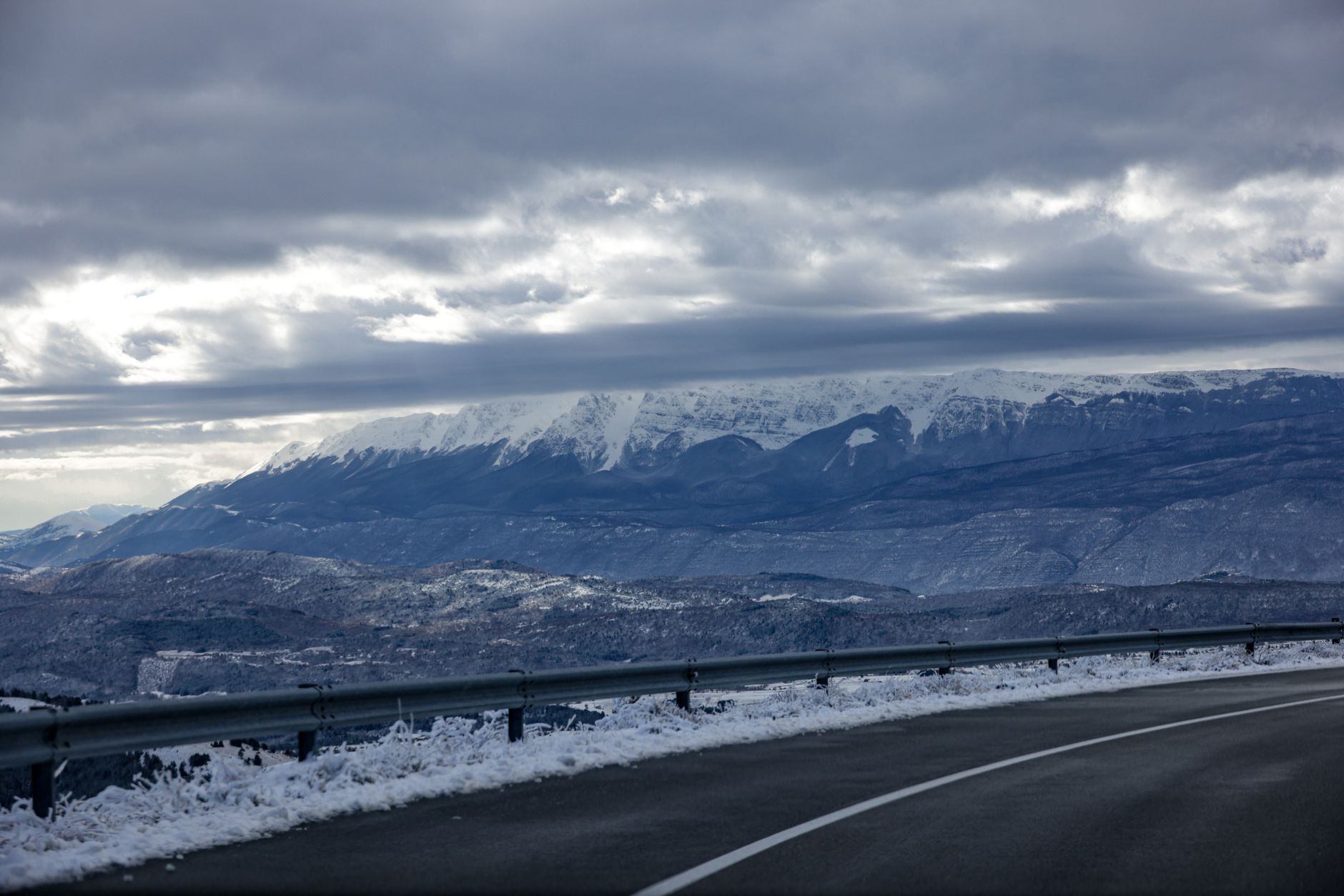 Winding mountain road covered in snow representing extreme driving conditions autonomous vehicles cannot yet handle