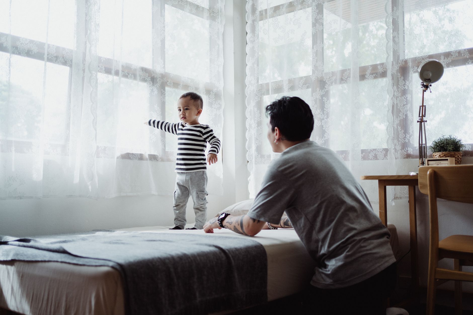 Toddler speaking with an adult caregiver in a home setting, representing early childhood language development