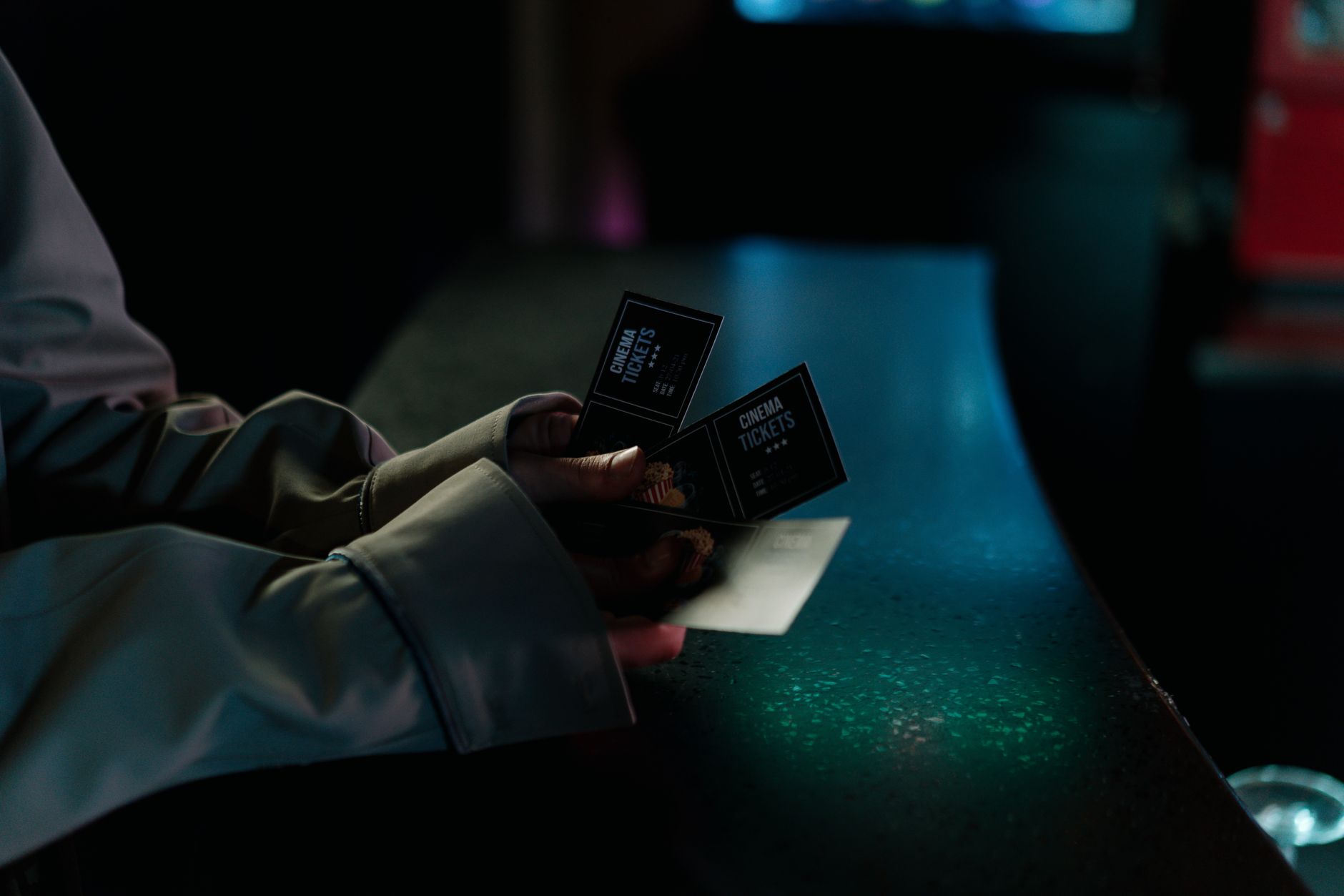 Person purchasing movie tickets at a cinema box office counter