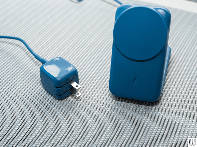 Phone, earbuds case, and smartwatch arranged on a multi-device charging stand