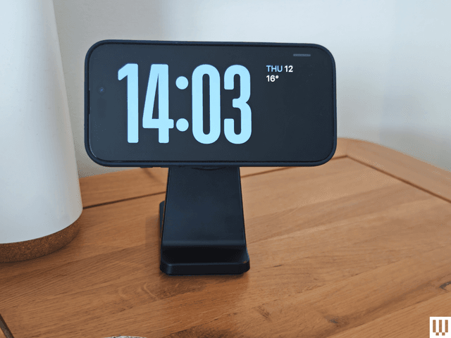 Compact wireless charging pad folded next to a smartphone in a travel bag