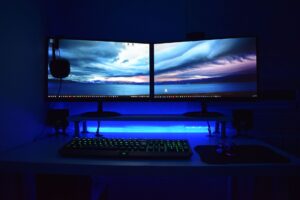 A high-resolution gaming monitor displaying a colorful game environment on a desk