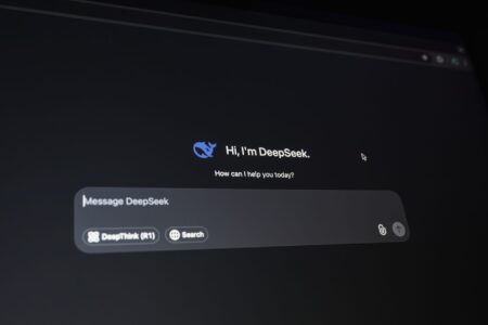 Claude Gets Document Creation and Cowork Tools for Paid Users Person using an AI chat interface on a laptop to create documents