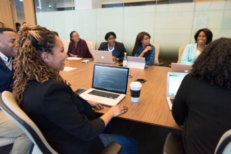Fortune 500 AI Agents Are Running Pilots. Few Are Running Businesses. Business professionals reviewing AI deployment strategy on screens in a modern office