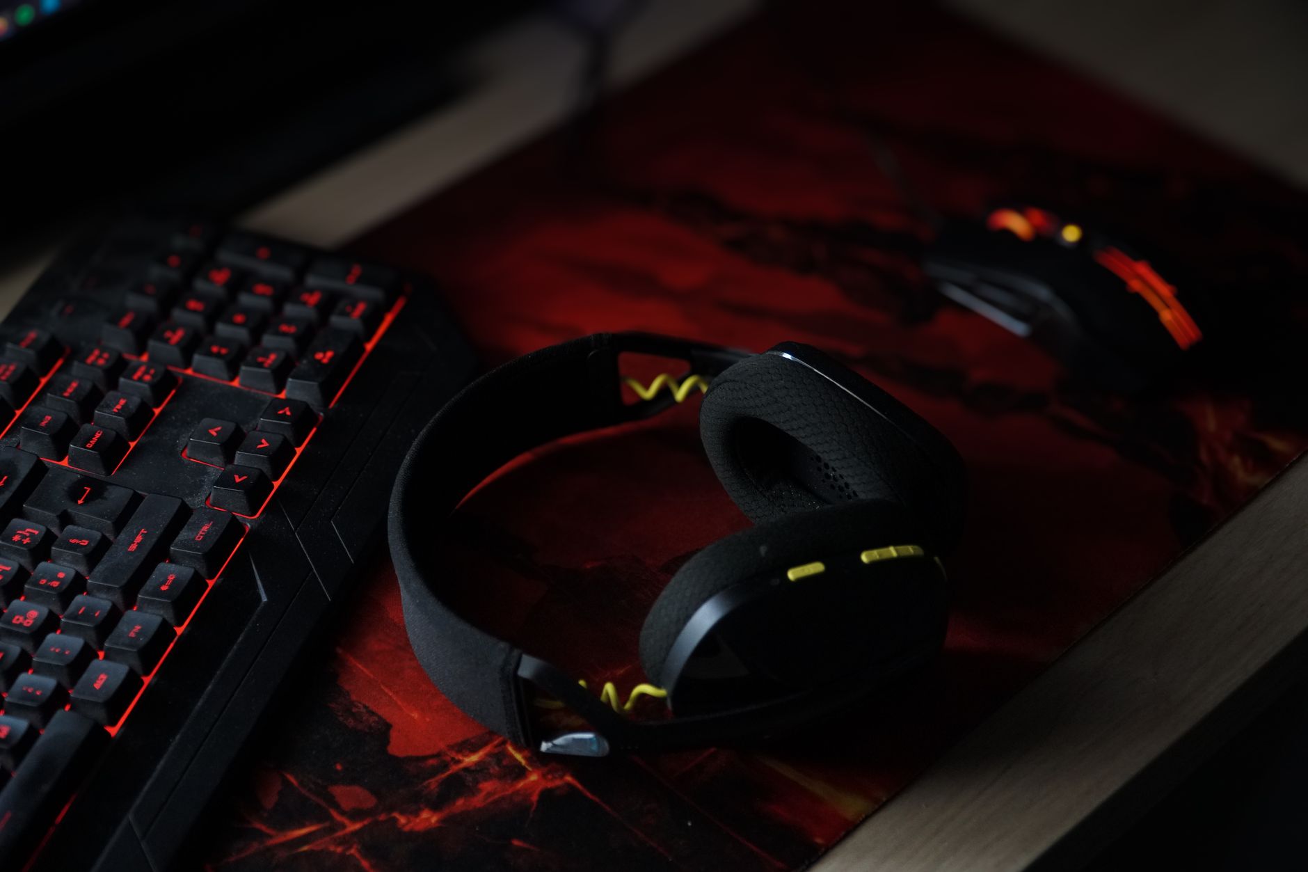 A pair of stereo headphones resting on a gaming desk setup
