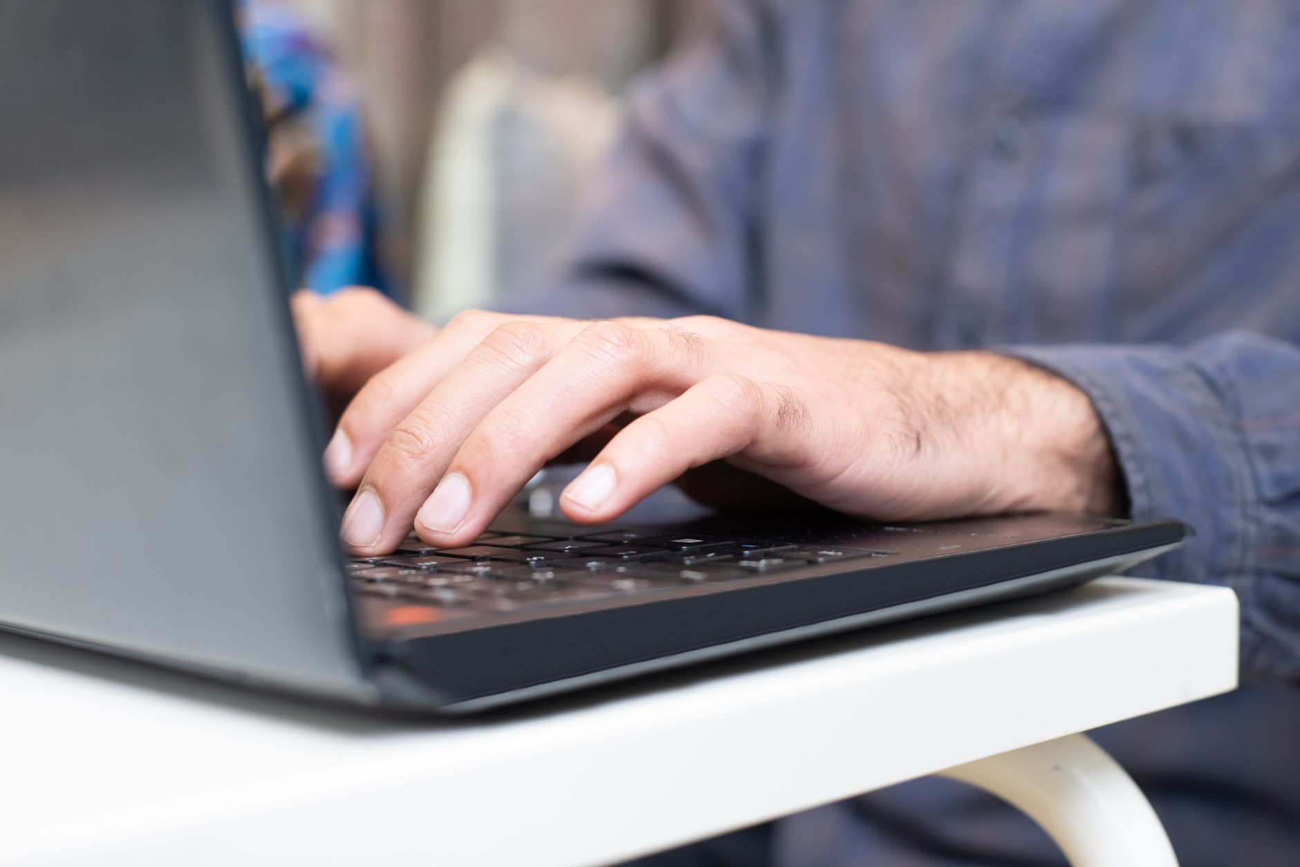 Person typing on a laptop, symbolizing online content submission and AI writing assistance