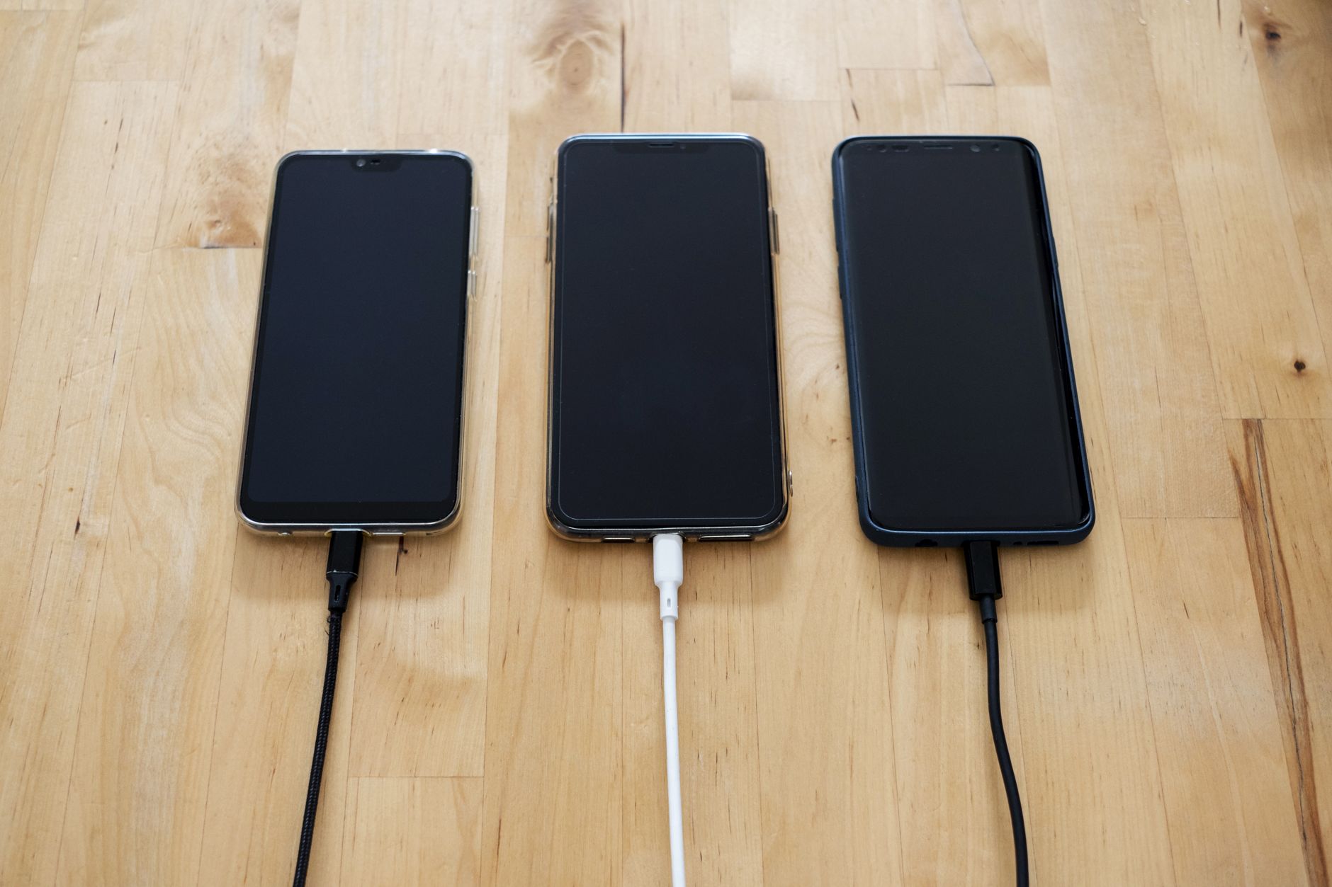 Smartphone resting on a wireless charging pad inside a vehicle center console