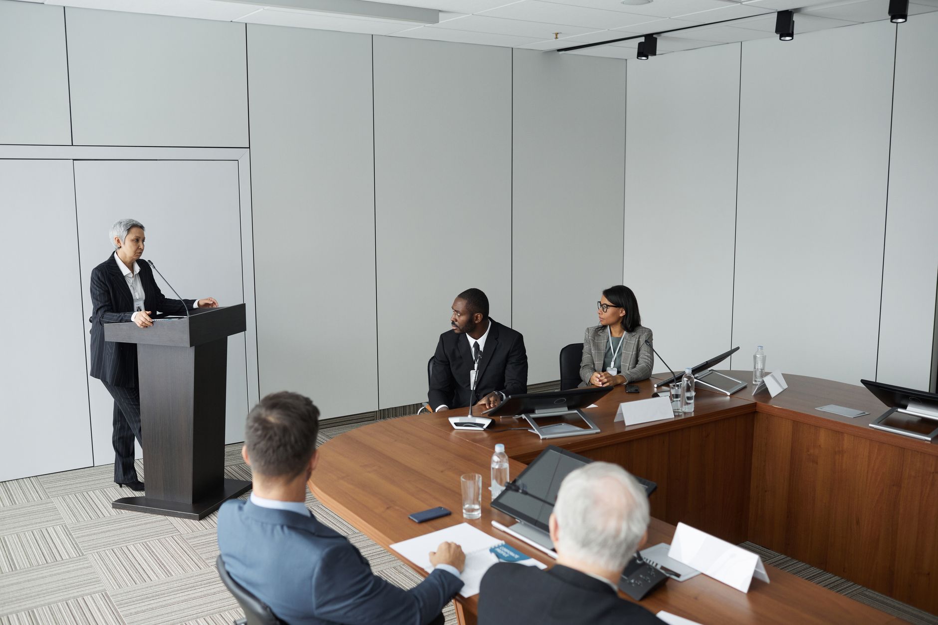 Three professionals seated at a roundtable discussion in a modern media studio setting