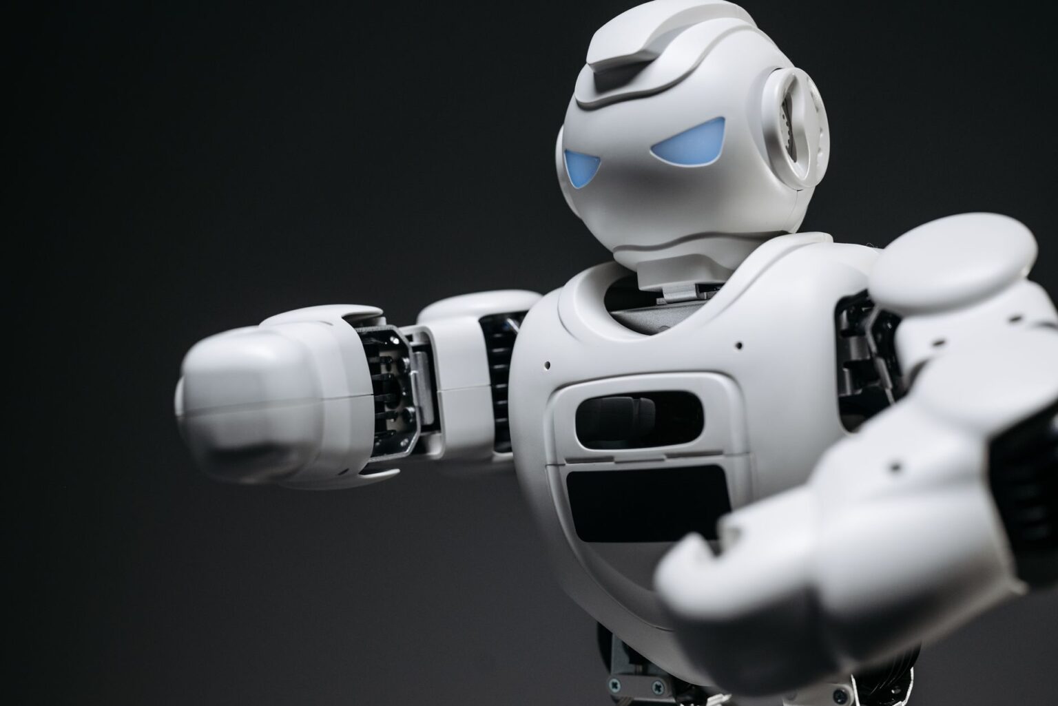 A humanoid robot standing in an industrial setting, representing the gap between robotic demos and real-world deployment