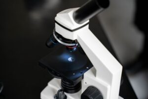 Researcher examining samples under a microscope in a university laboratory setting