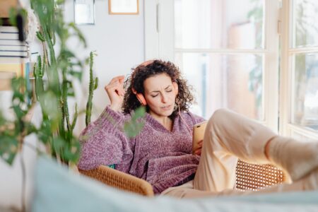 Person listening to music through headphones on a smartphone streaming app