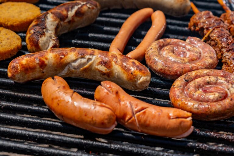 A wireless meat thermometer inserted into a piece of meat on a grill grate