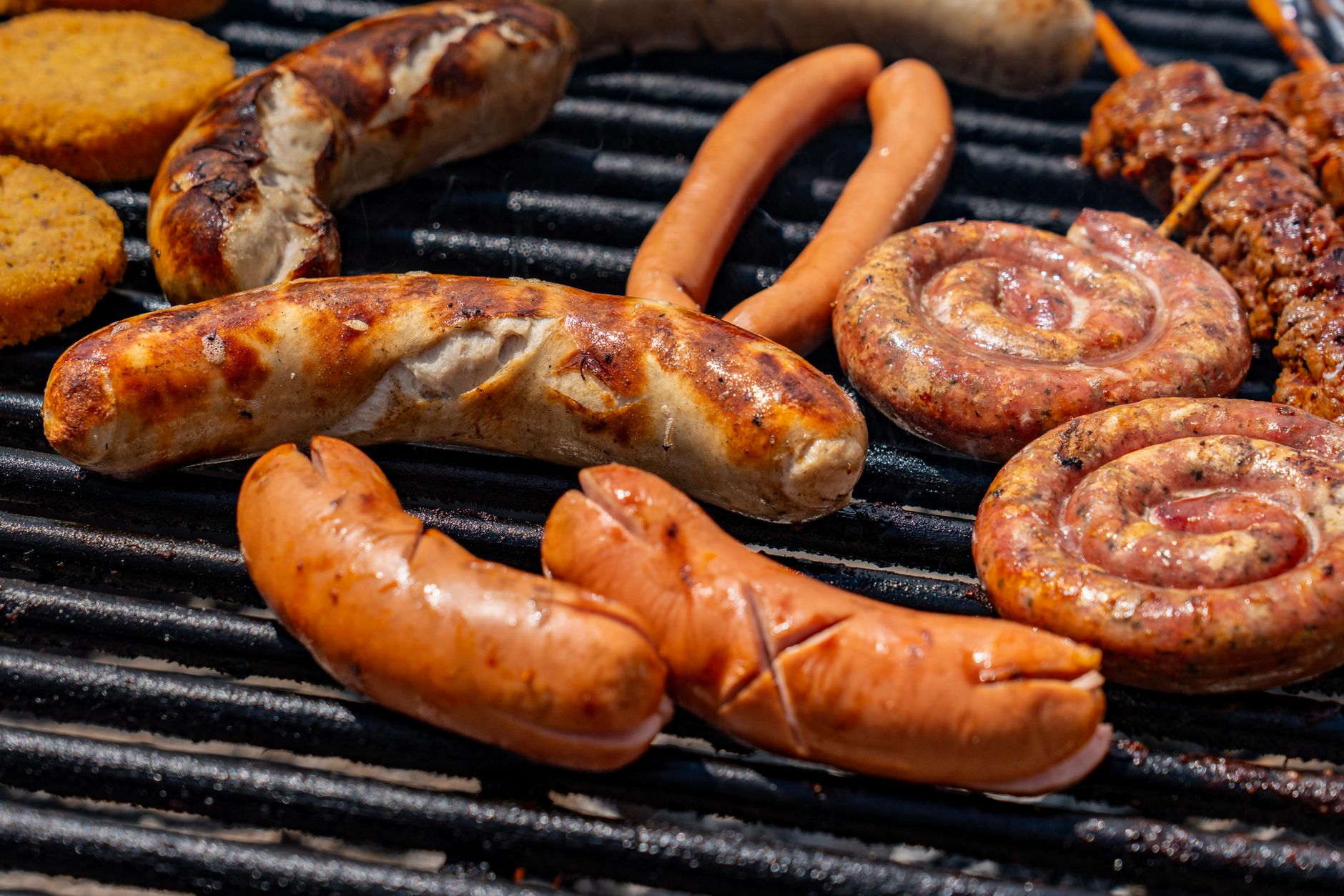 A wireless meat thermometer inserted into a piece of meat on a grill grate