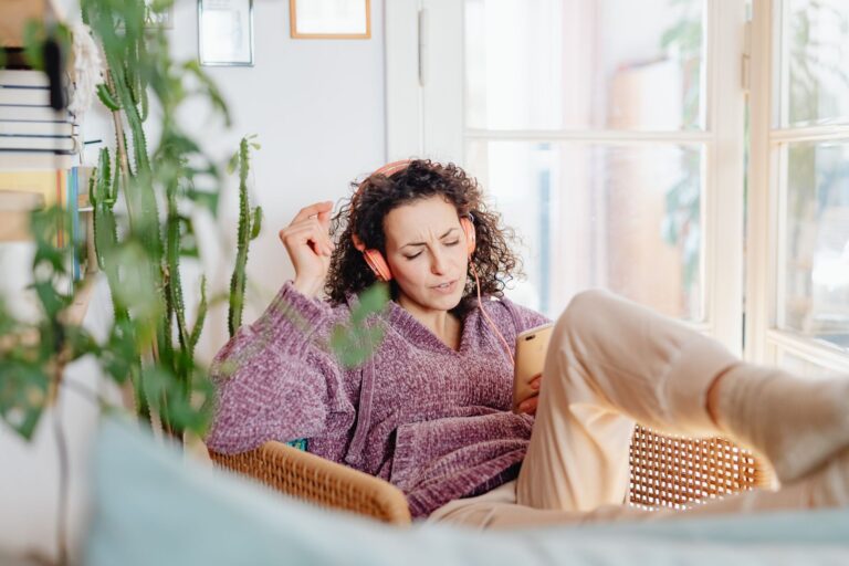 Person listening to music through headphones on a smartphone streaming app