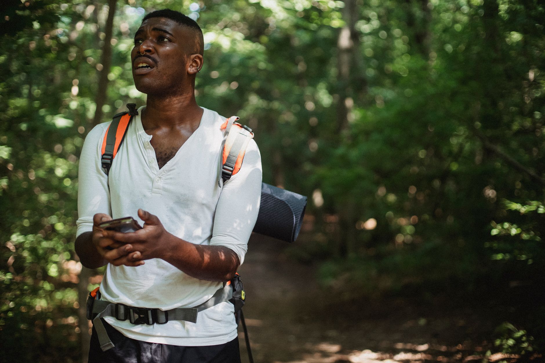 Trail runner checking GPS watch during outdoor run on mountain path