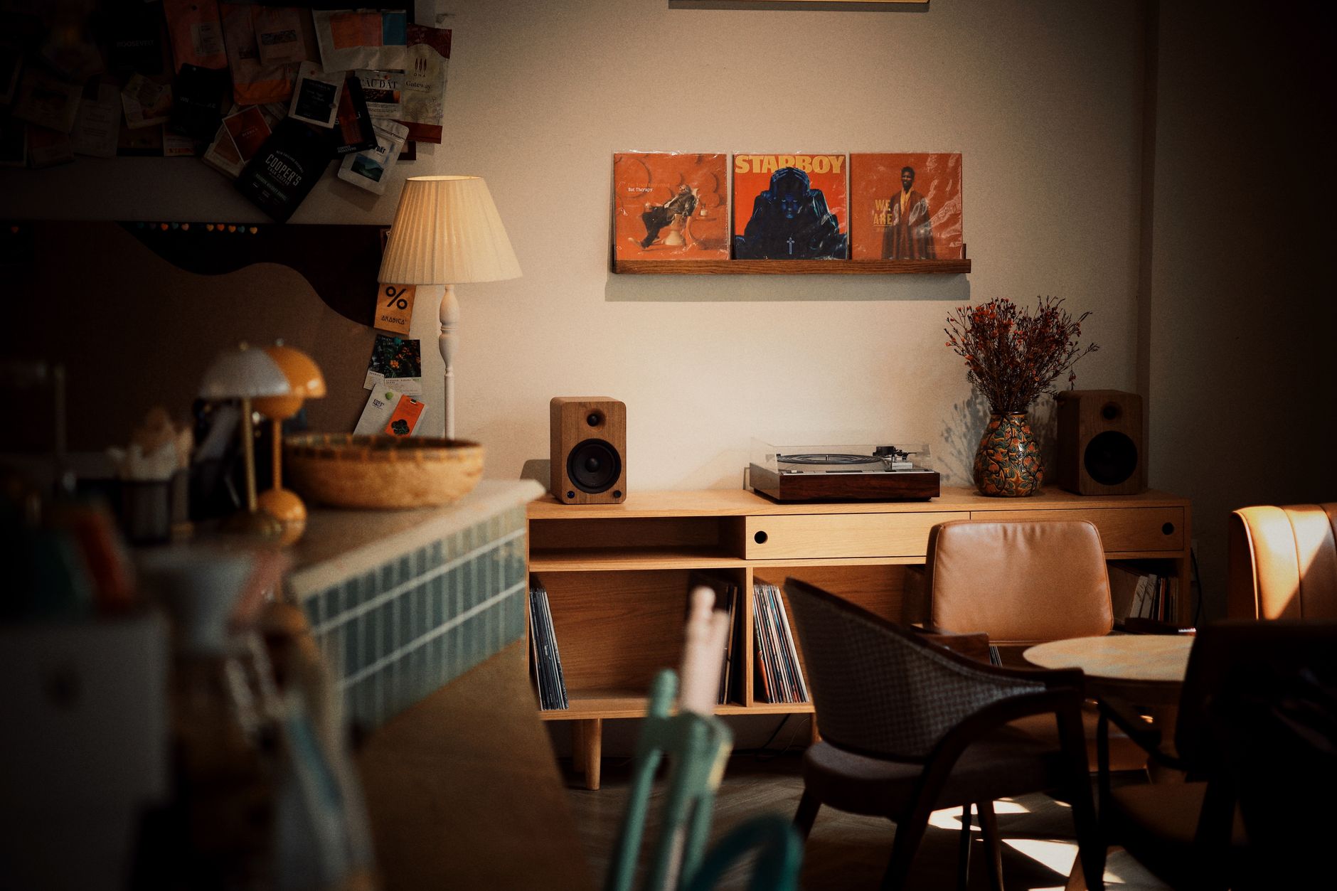 A pair of bookshelf speakers on a wooden shelf in a living room