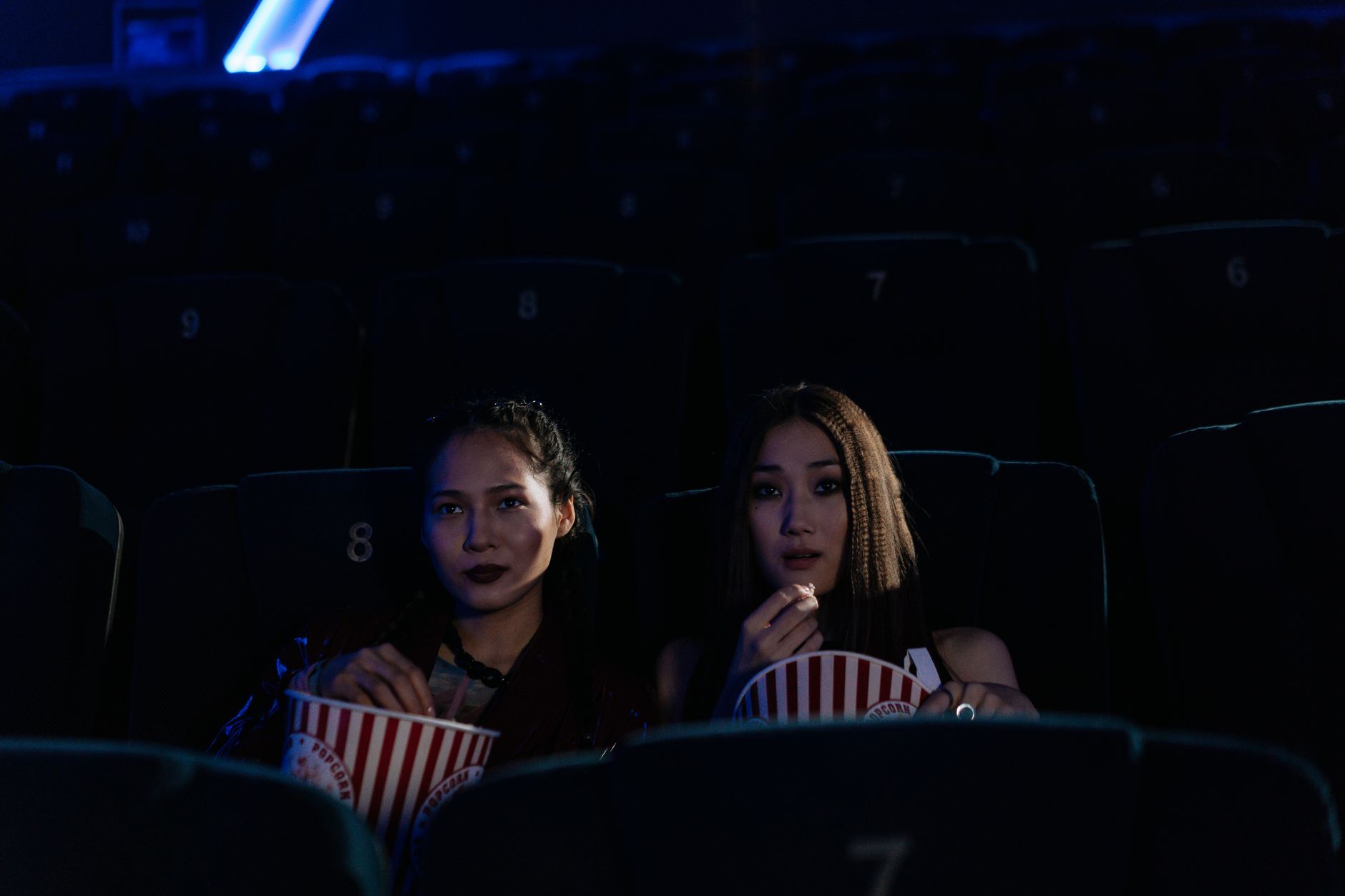 Dark cinema auditorium with rows of seats and dim lighting