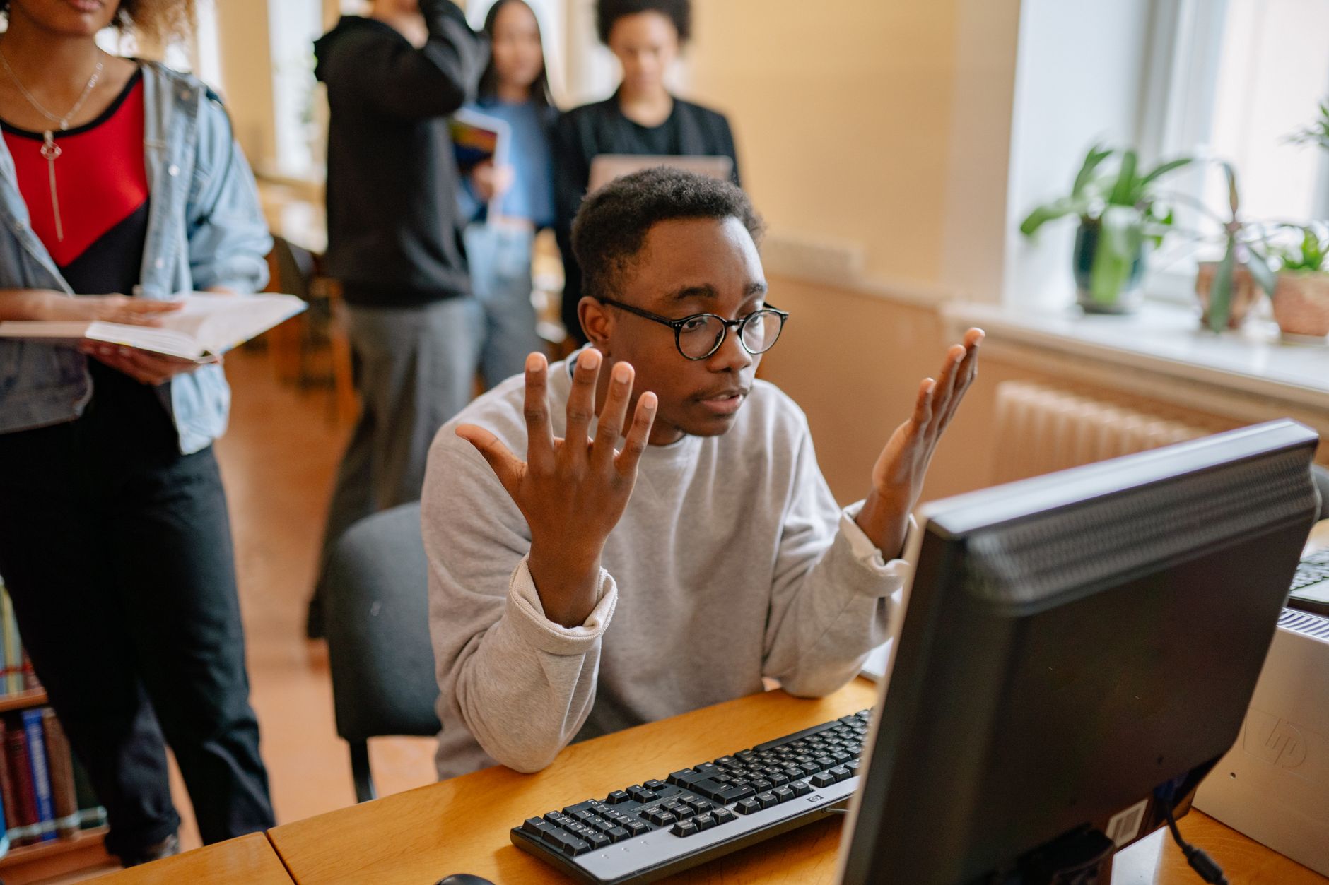 Person sitting at a computer looking concerned while reading something on screen