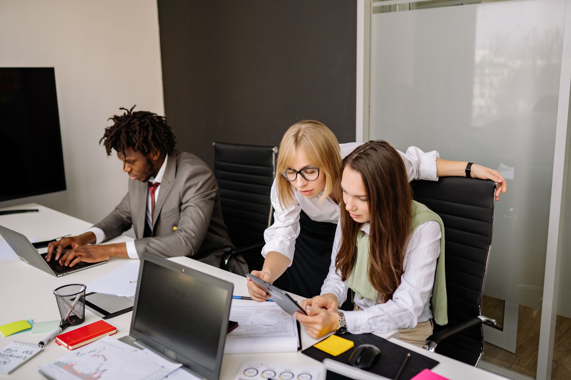 Technology executives reviewing data on screens in a corporate office setting