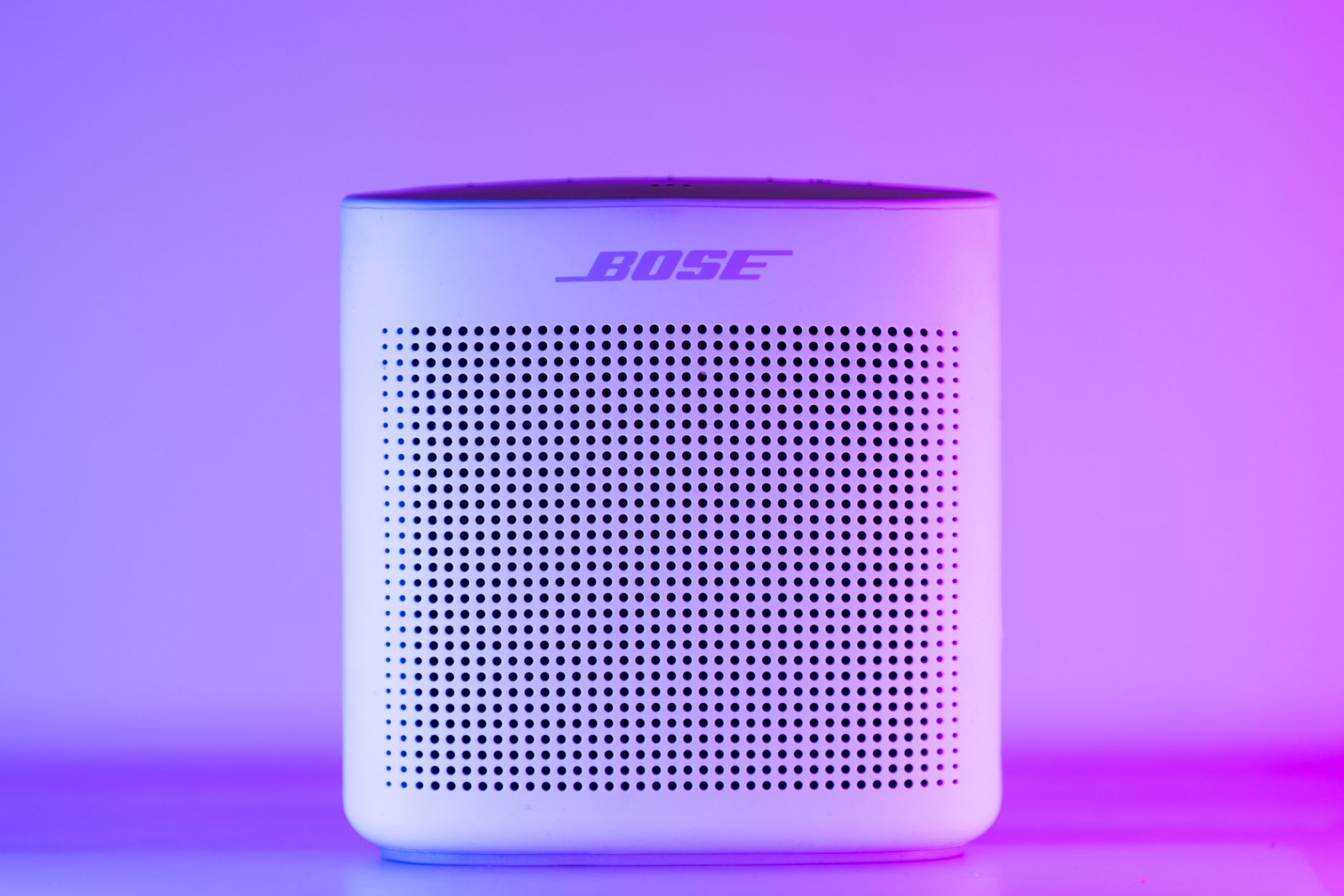 Wireless speaker on a desk next to a smartphone playing music