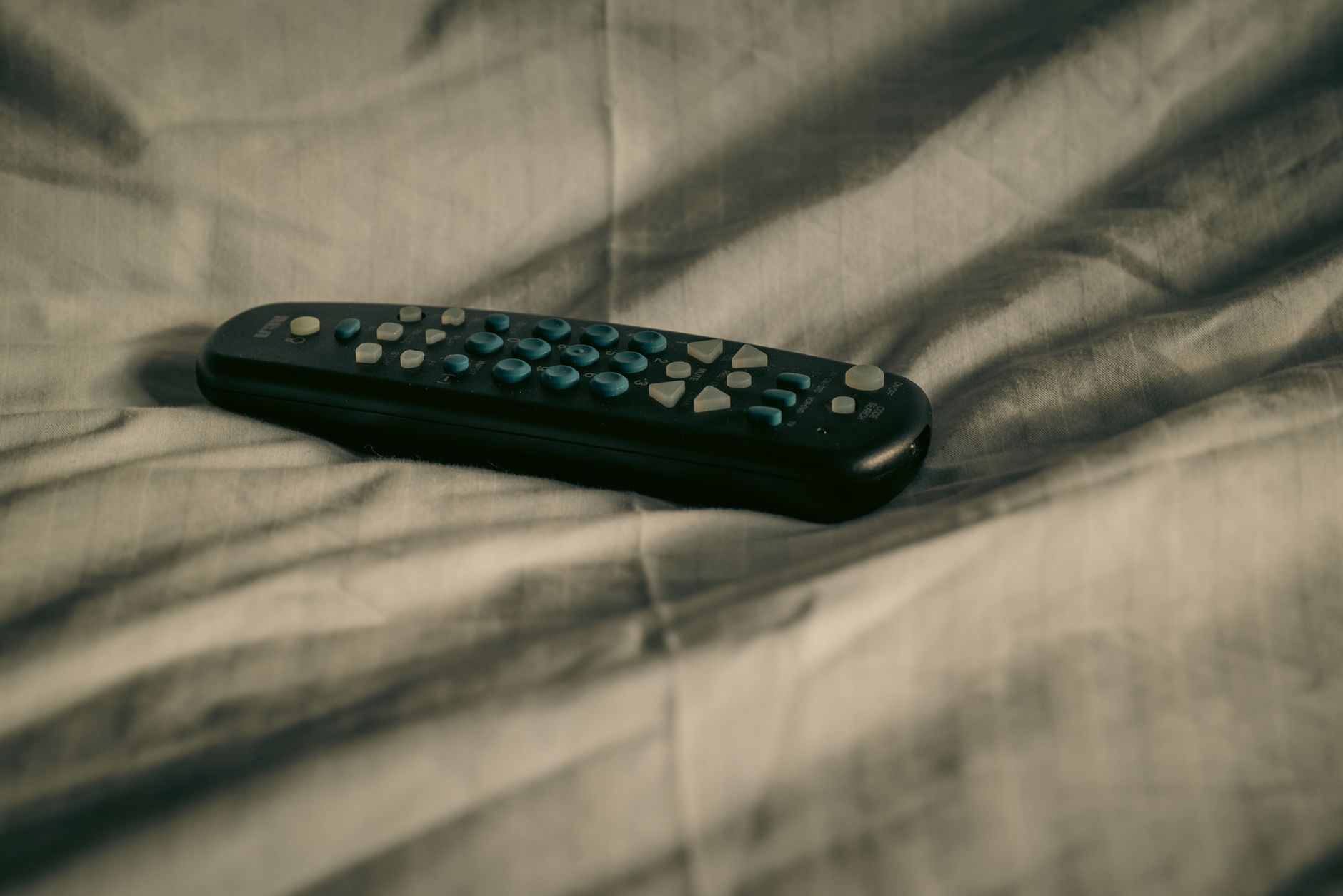 Person using remote control to stream sports on television