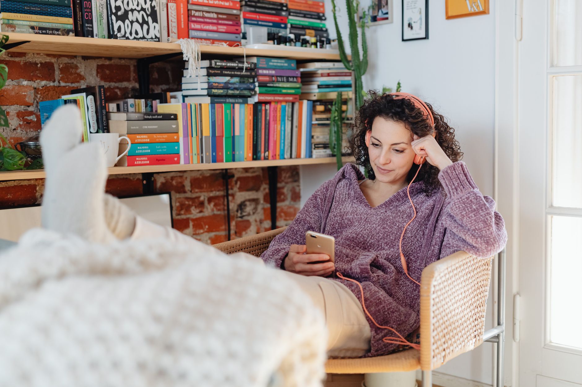 Person relaxing at home while listening to music through a speaker system