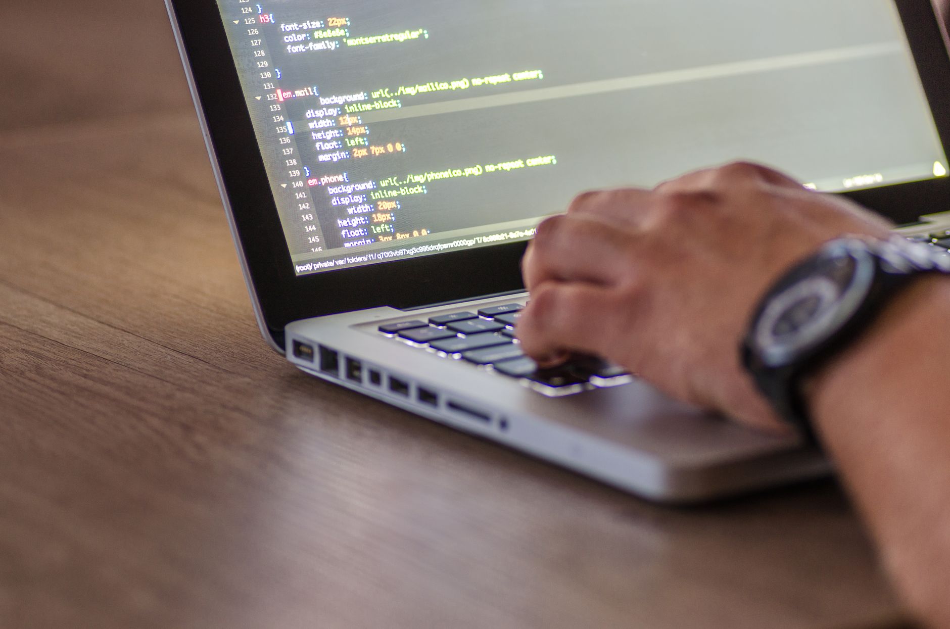 Software developer working at a computer reviewing programming code