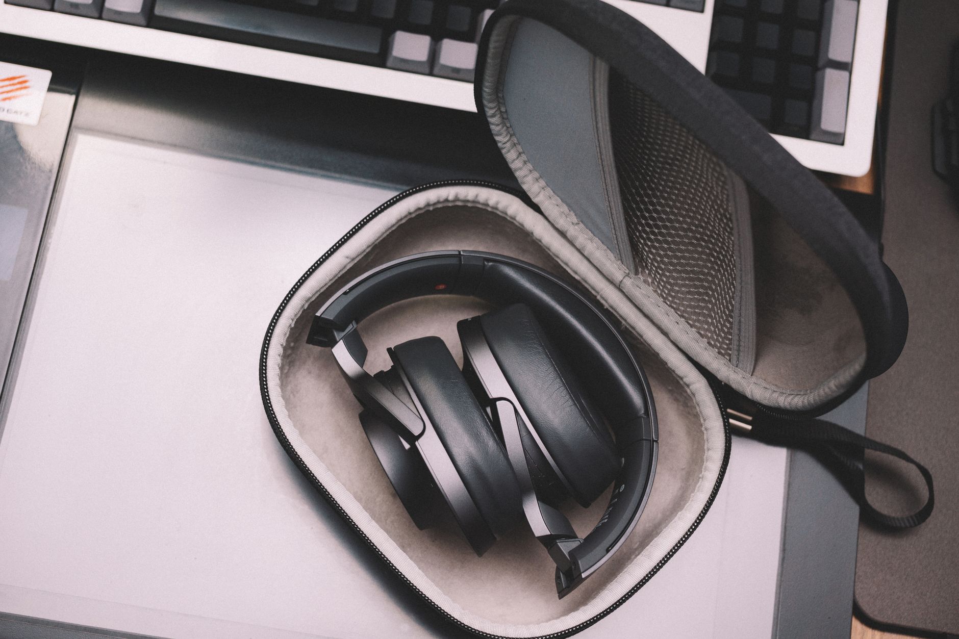 Over-ear headphones resting on a desk beside audio gear