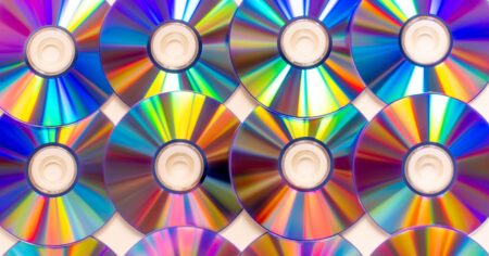 Streaming Fatigue Is Sending Listeners Back to Physical CDs Stack of CDs on a shelf representing a physical music collection